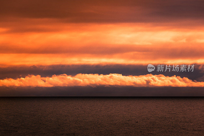 戏剧性的日落和平静的海面上的云景