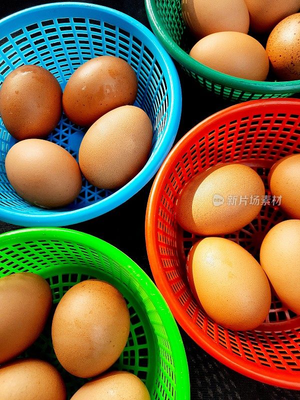 棕色的鸡蛋在彩色的篮子-食物准备。