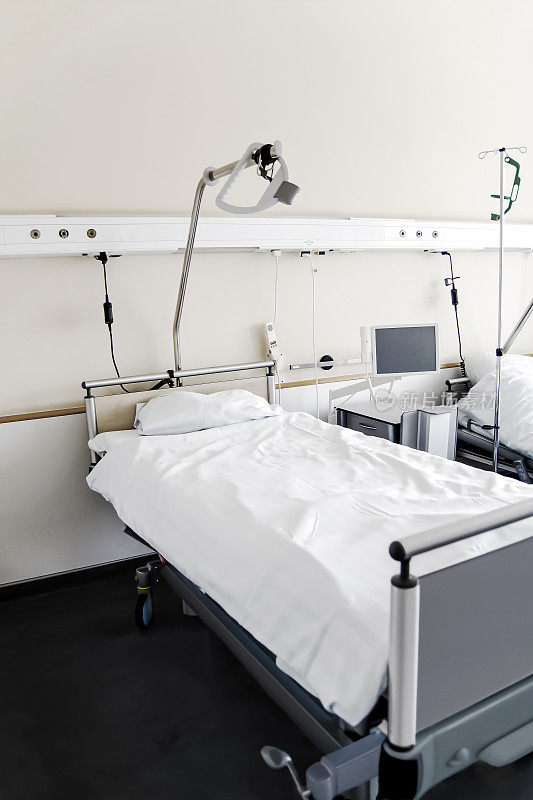 在一间空无一人的病房里。在医疗中心有床位的空房间。黄色的房间设计。白布床垫。医院里病人的卧室。