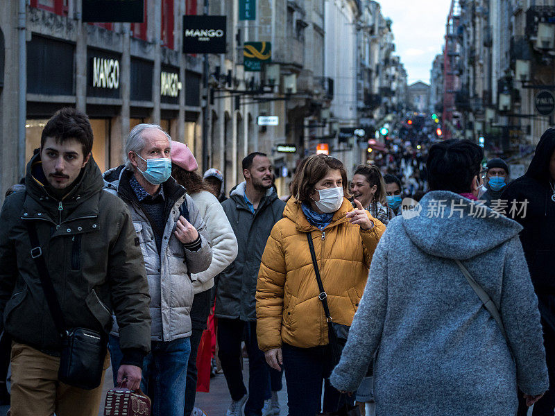 新冠肺炎期间，戴口罩的老年男女夫妇走在波尔多圣凯瑟琳拥挤的街道上。