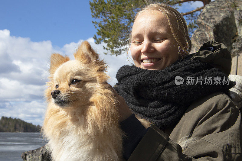 年轻女子肖像与博美犬，自然背景