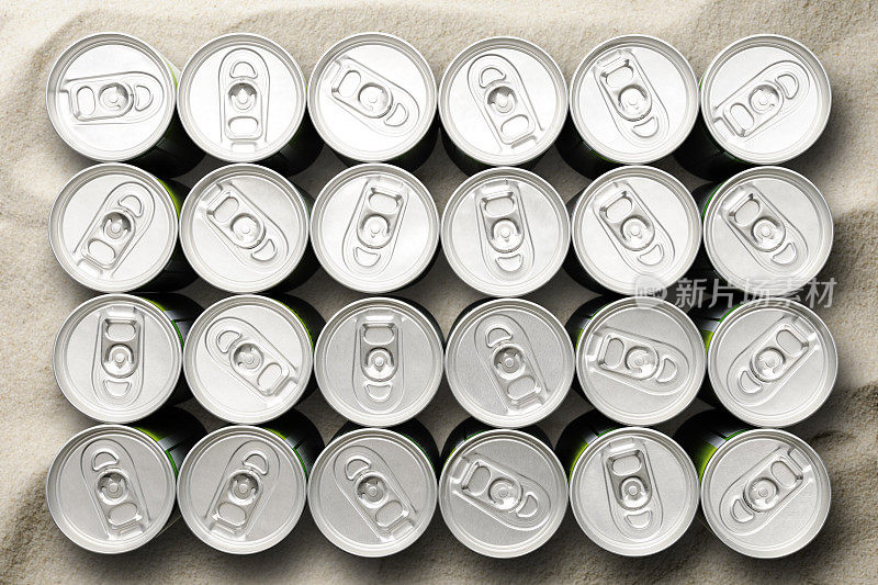 沙滩上未打开的小饮料罐的俯视图