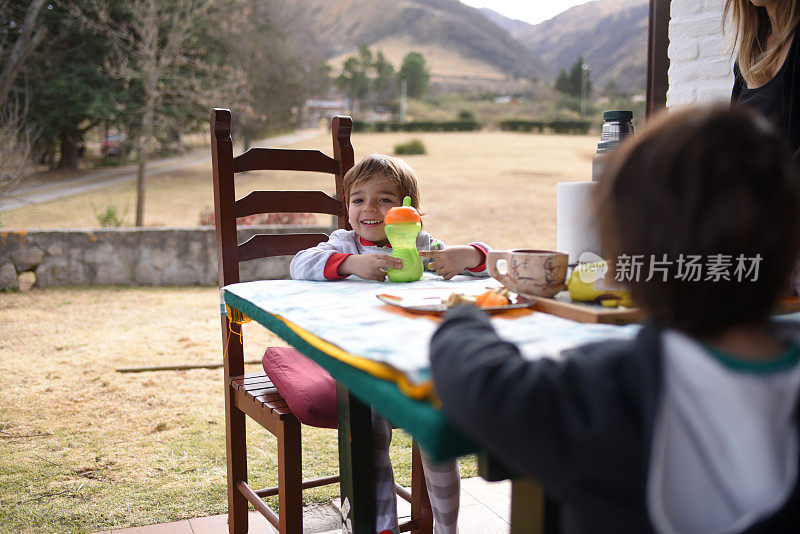 和孩子们一起吃早餐的妇女