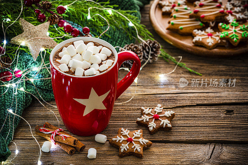 红色热巧克力杯与棉花糖和饼干在圣诞餐桌上
