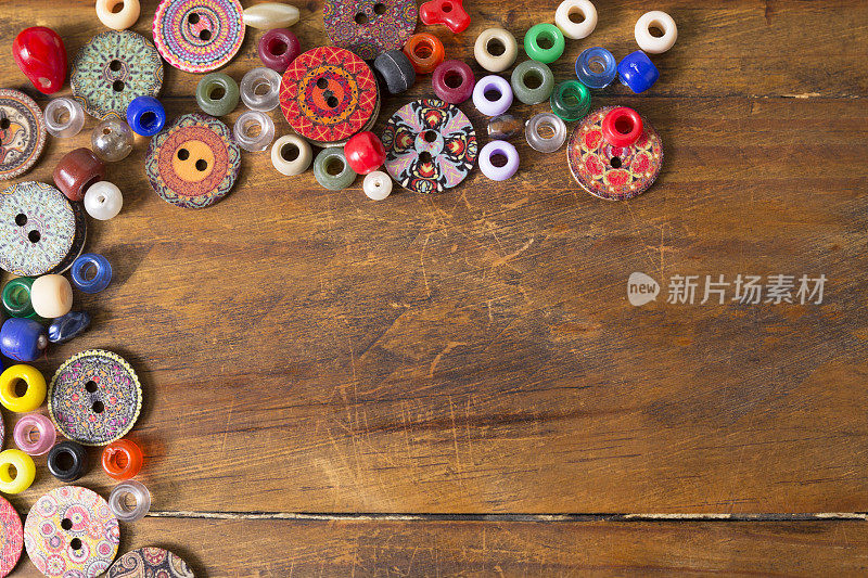 木质工艺桌上的彩色纽扣和珠子。伟大的背景图像。爱好。