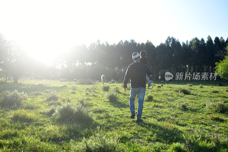 父子俩走在田地里