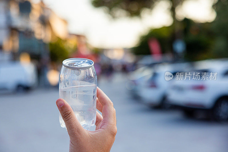 不认识的女人拿着装着水的塑料罐