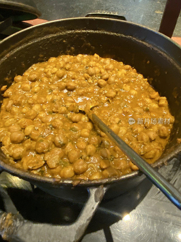 卡德海风格的自制旁遮普chole(鹰嘴豆咖喱)食谱的特写图像，浸泡鹰嘴豆与磨碎的洋葱，番茄泥，香草和香料，香菜装饰，高架视图