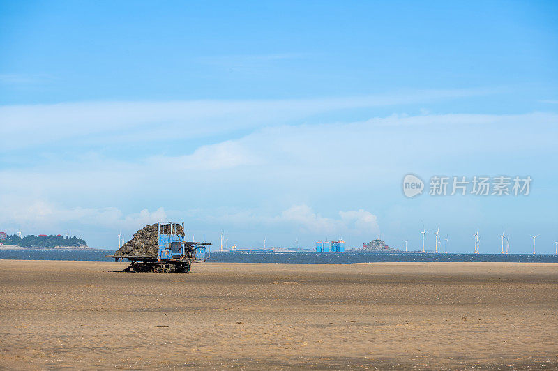 在蔚蓝的天空和大海上，金色的沙滩上有一辆运货车