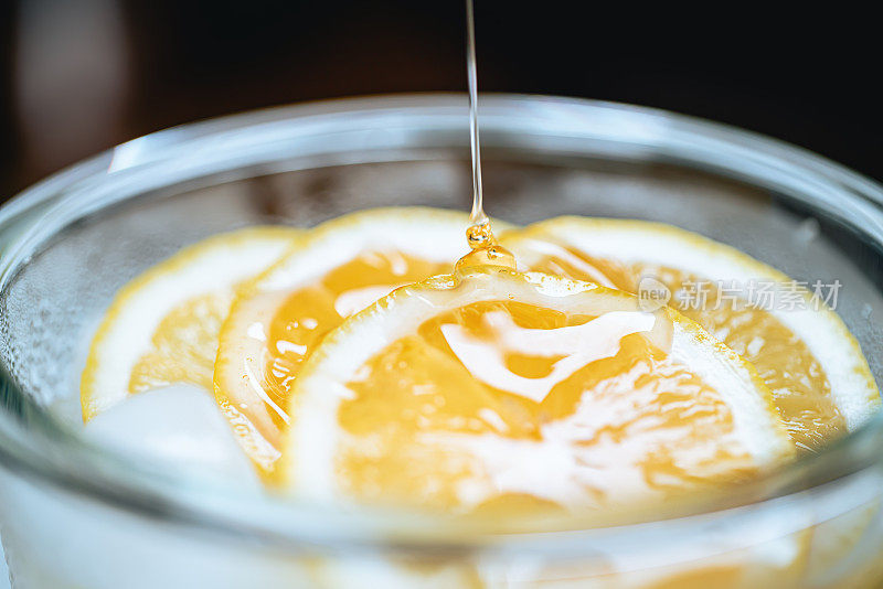 蜂蜜滴在冰块上的柠檬片上