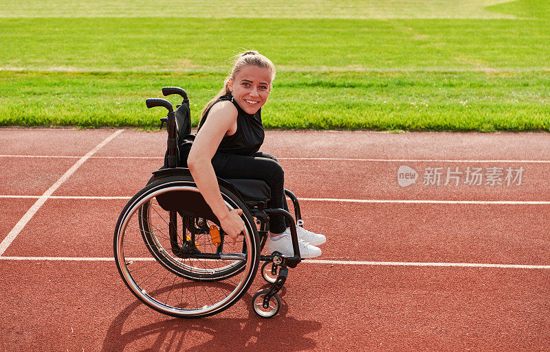 在为残奥会做准备时，在跑道上驾驶轮椅的残疾妇女