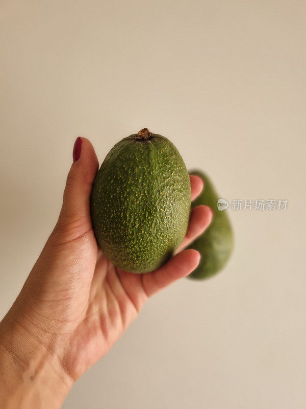 一个女人手里拿着牛油果