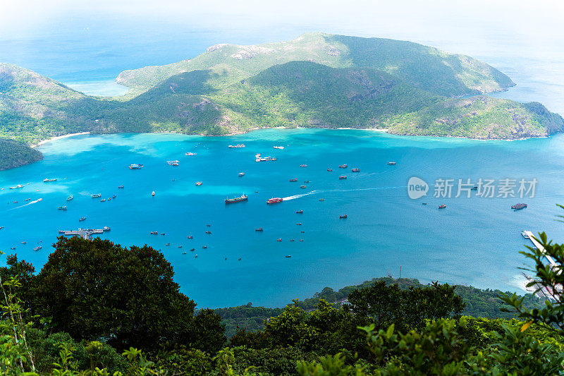 越南孔岛本丹港，湛蓝的大海，蓝天山和五颜六色的船只。