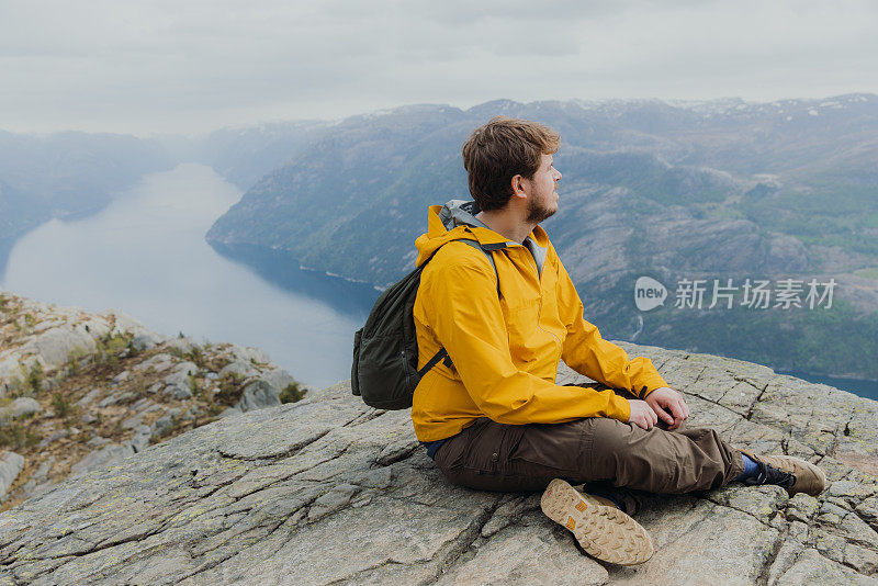 一个快乐的人从挪威风景优美的吕瑟峡湾俯瞰风景