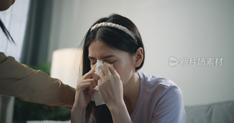 年轻的专业治疗师一边哭泣一边抚摸女病人的肩膀