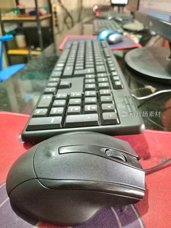 办公桌上的电脑鼠标和打字键盘。