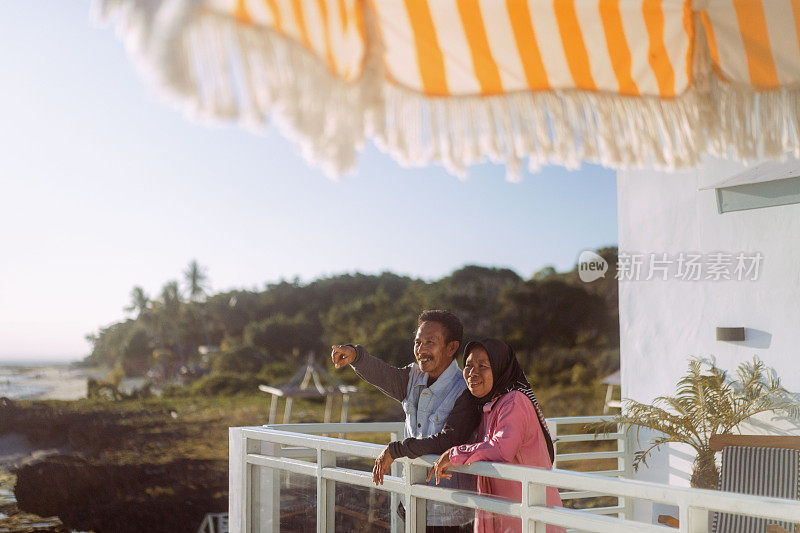 成熟的穆斯林夫妇在海滨别墅享受日落