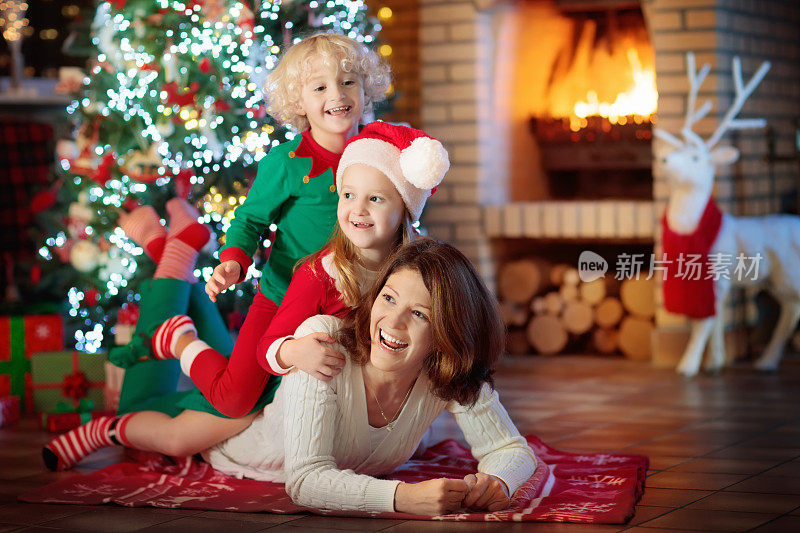 家庭和孩子们在圣诞树和壁炉旁。