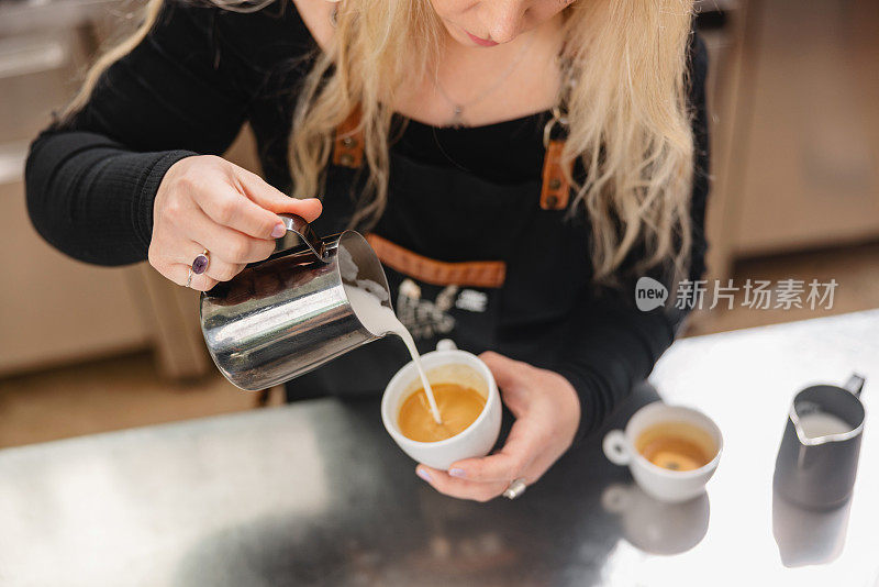 一位白人女咖啡师在做拉花艺术