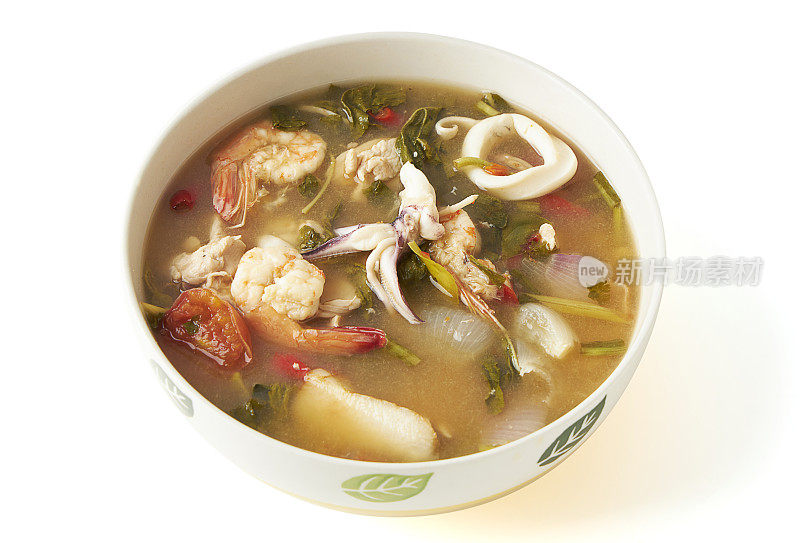 泰国麻辣混合海鲜汤(虾和鱿鱼)与草药碗隔离在白色背景。味道浓烈的酸辣汤，在泰国很受欢迎。(汤颜宫清汤)