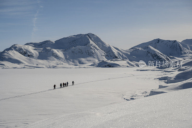 滑雪登山运动员攀登白雪皑皑的山峰