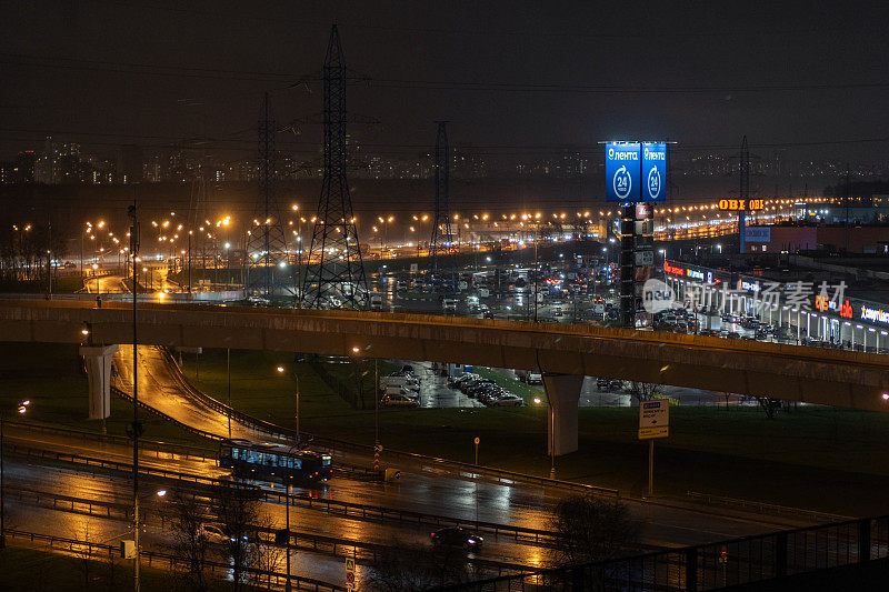 在夜间的道路上，汽车驶过一座桥和一个路口。城市城市