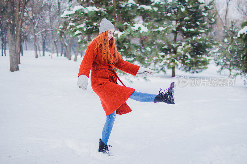 女人在冬天的公园玩雪