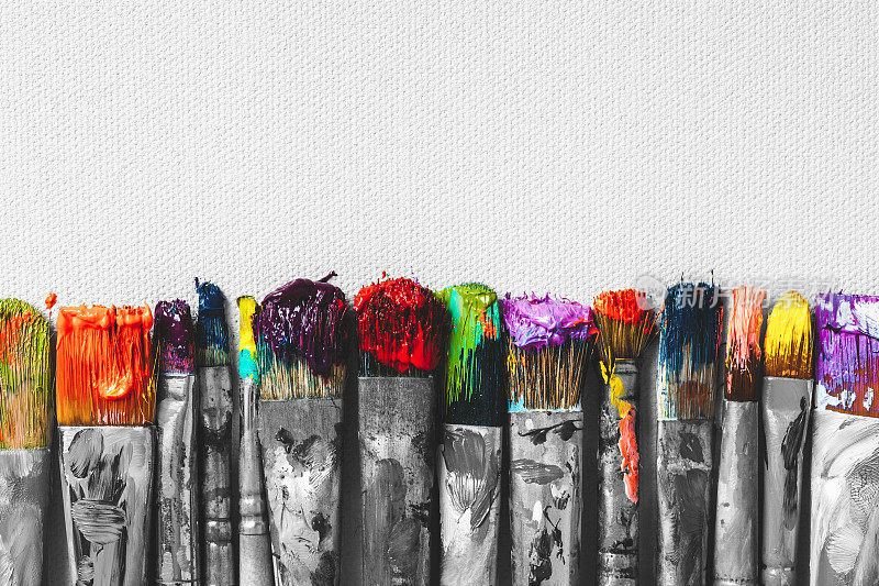 排艺术家的画笔与彩色的鬃毛特写艺术画布背景，复古的黑白风格化。