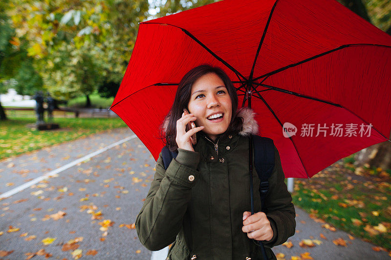 年轻女子与手机在雨天