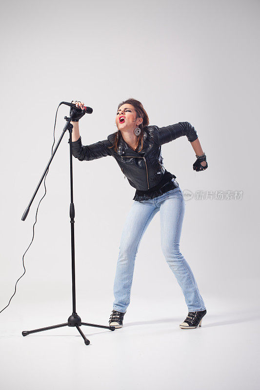 女摇滚歌手拿着麦克风站在台上