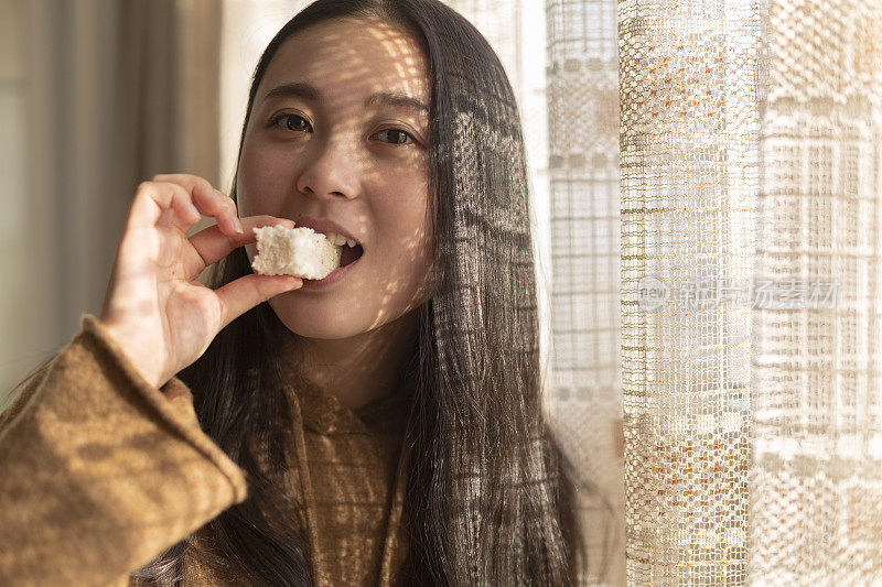 快乐的女人在家里吃零食