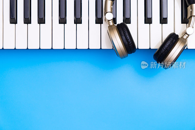 音乐键盘与金色耳机为蓝色复制空间下面