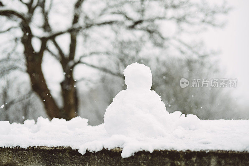 在一个下雪的冬天，墙上的迷你雪人。