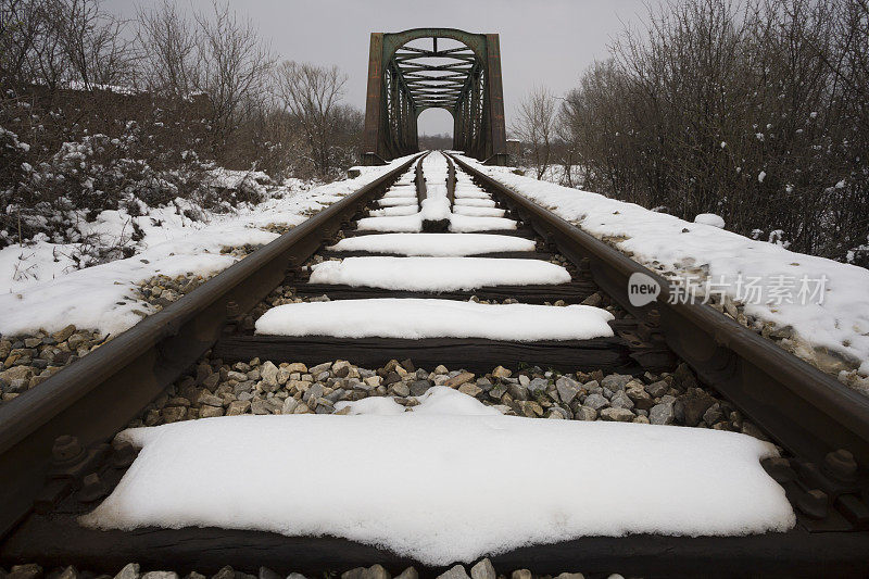 旧铁轨和铁路桥上覆盖着积雪
