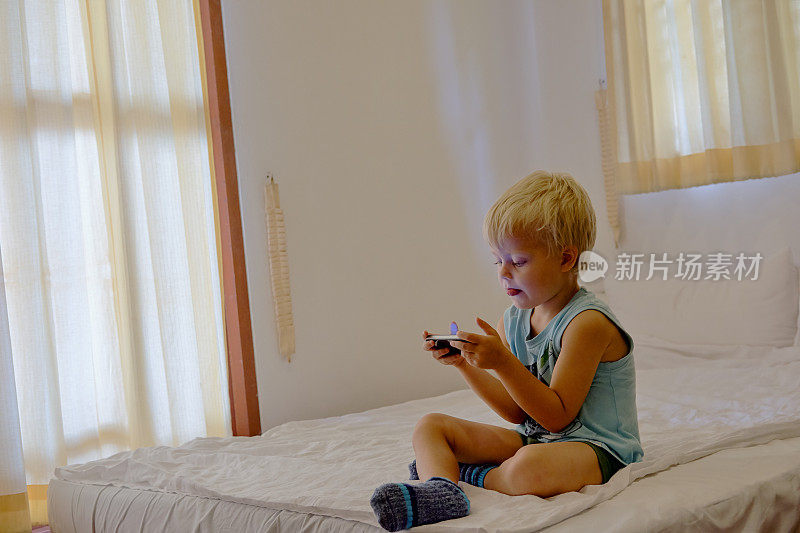男孩在便携式设备上玩电子游戏