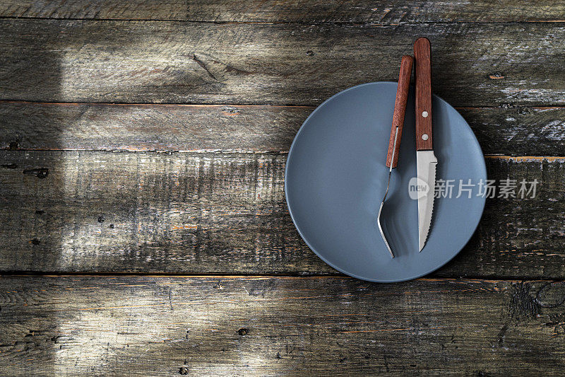 叉子、餐刀和空盘子放在桌上