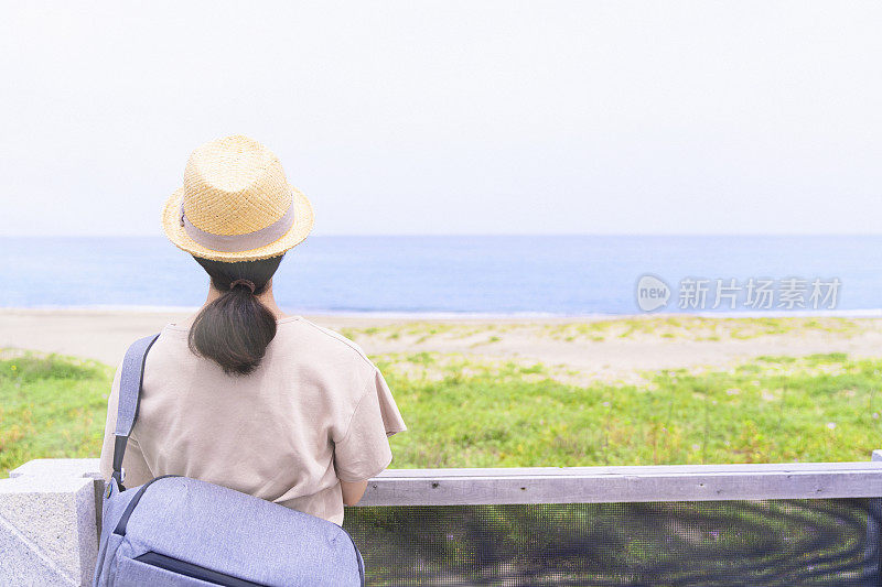 从人行天桥上看海岸的女游客