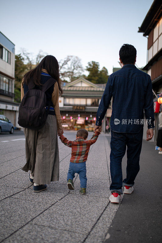 年轻的家庭在传统的日本小镇散步