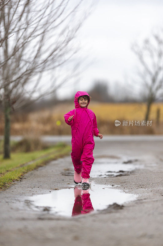 小女孩在乡下的水坑里奔跑