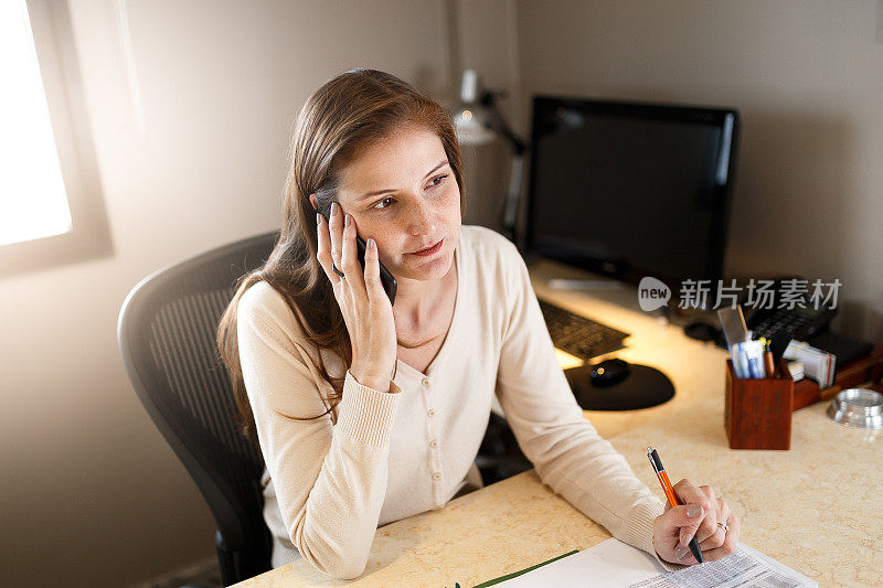 在办公室使用智能手机的女性