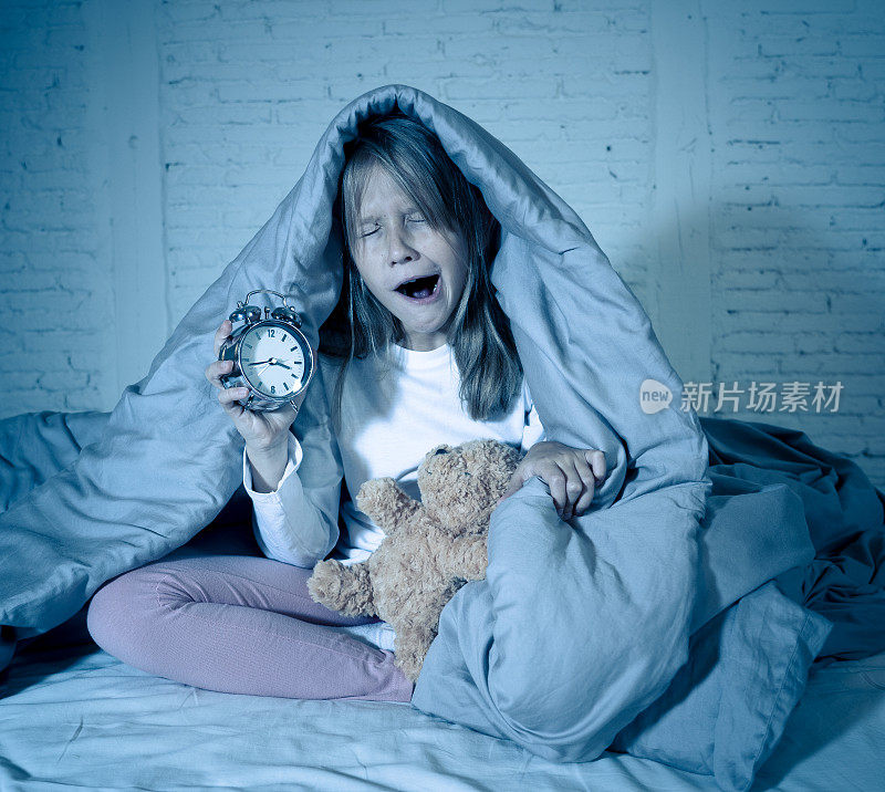 可爱的不眠之夜的小女孩坐在床上看起来悲伤和疲倦有睡眠问题晚上睡不着或早上醒来太早在失眠焦虑儿童睡眠障碍。