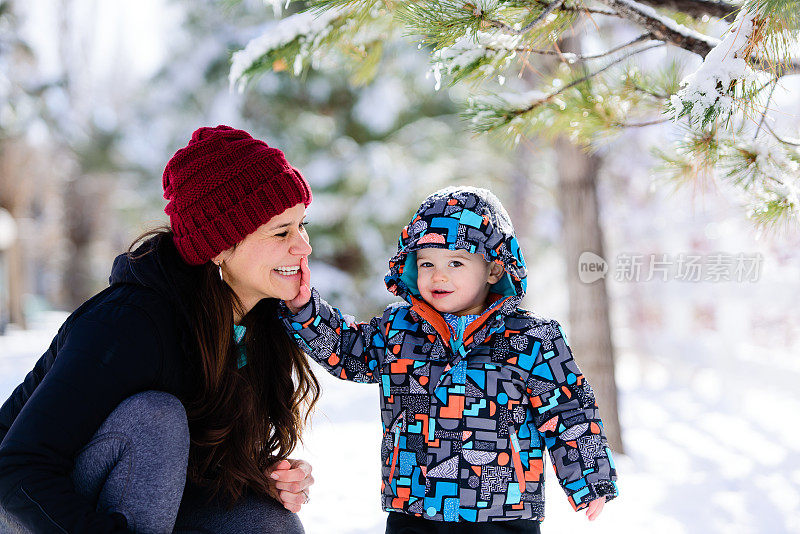 和妈妈一起在雪地里快乐地蹒跚学步