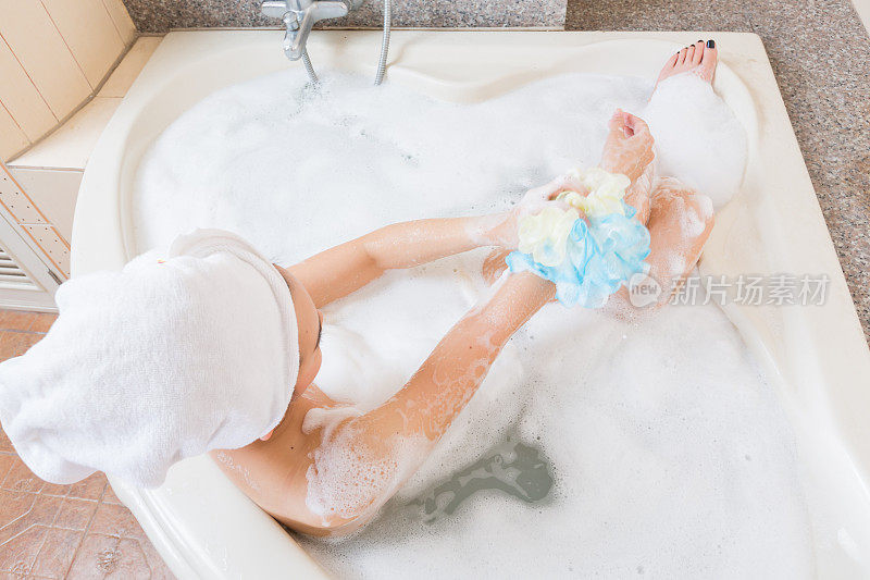 美丽的女孩在浴缸洗澡和洗手。