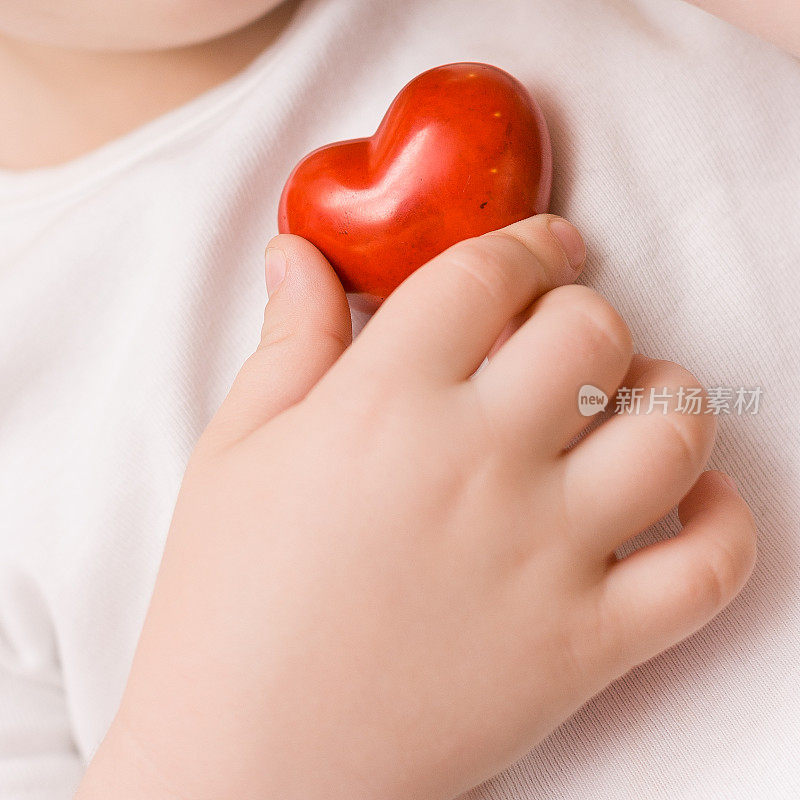 小红心握在孩子手里。爱。护理。医疗保健。