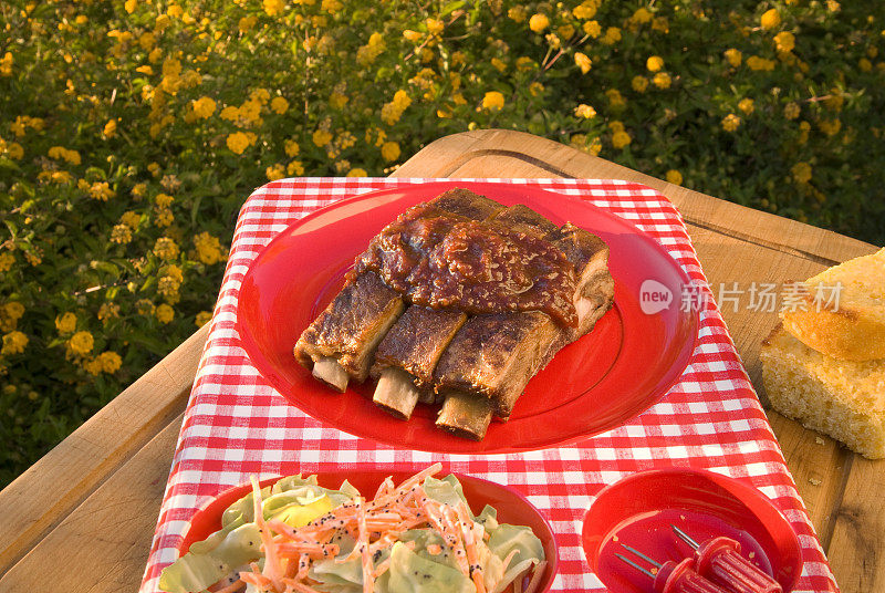 烧烤排骨，户外排骨野餐桌，玉米面包和凉拌卷心菜