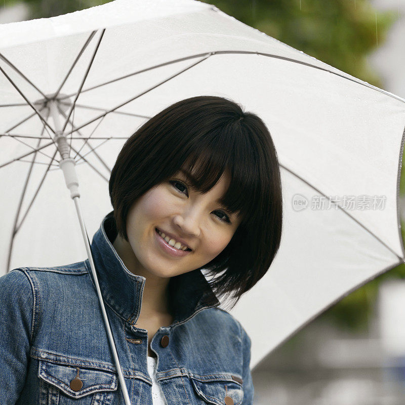 年轻的亚洲女人拿着一把伞