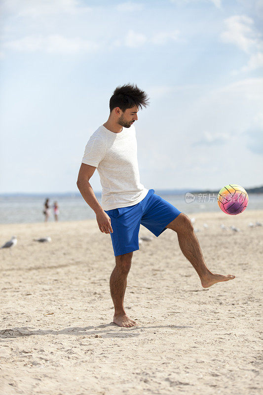 男人在沙滩上踢球