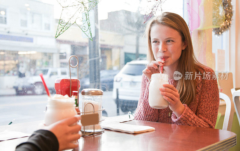 十几岁的女孩喝着奶昔