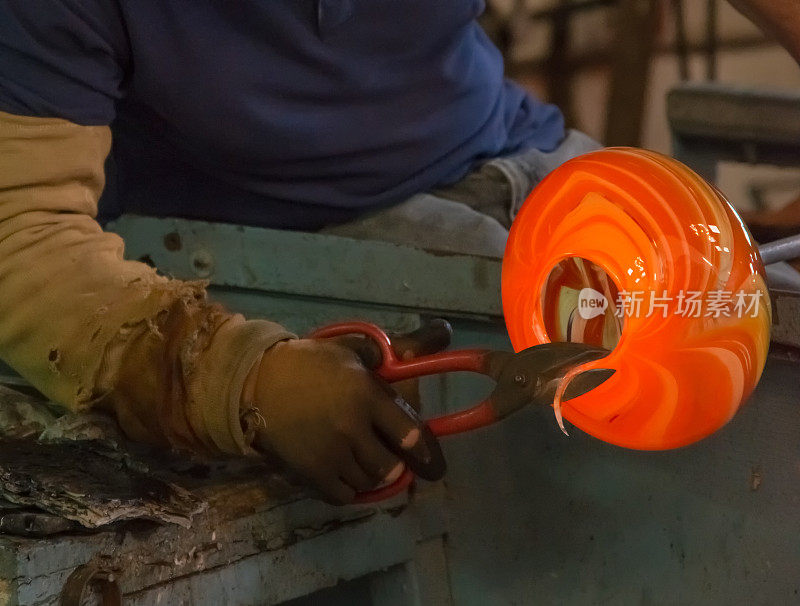 传统的玻璃吹制工人切割液体玻璃