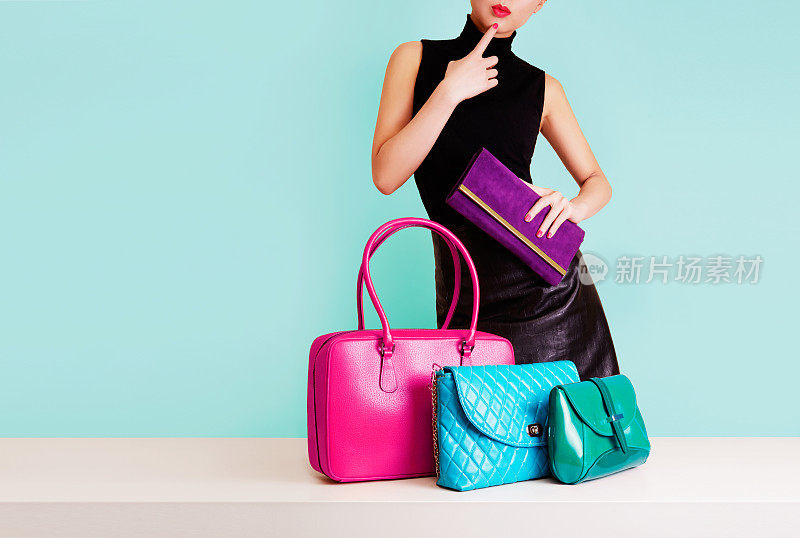 女人思考着许多彩色的袋子。购物。时尚的形象。